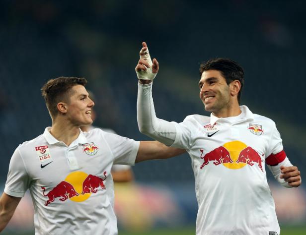 Zwei Fußballspieler von Red Bull Salzburg feiern gemeinsam auf dem Spielfeld.