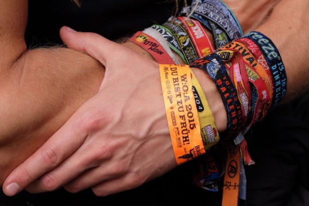 Ein Arm ist mit zahlreichen Festivalbändchen geschmückt, darunter Wacken Open Air (W:O:A) 2015.