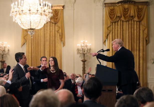 A White House staff member reaches for the microphone held by CNN's Jim Acosta as he questions U.S. President Donald Trump during a news conference in Washington