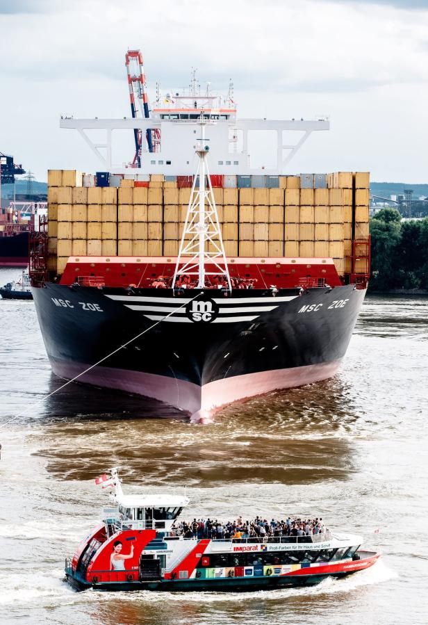 Das Containerschiff „MSC Zoe“ fährt auf der Elbe, während ein Ausflugsdampfer vorbeizieht.