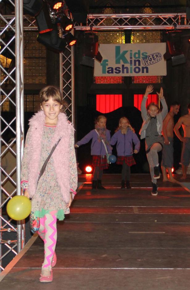 Kinder präsentieren Mode auf einer Bühne bei „Kids in Jugend Fashion“.