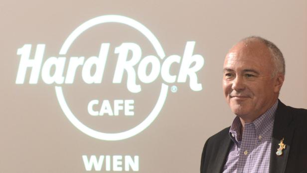 Ein Mann steht vor einer Projektion des Hard Rock Cafe Wien Logos.