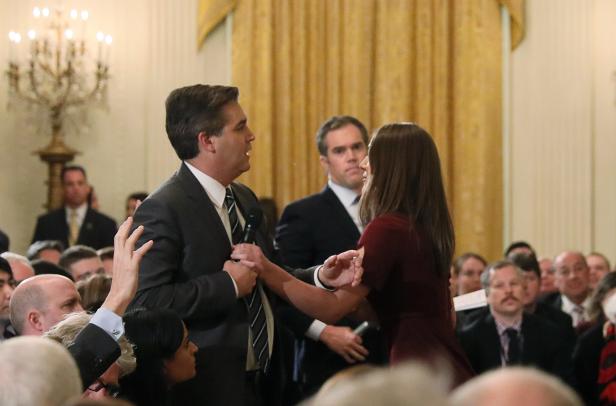 White House intern reaches for microphone held by CNN's Acosta as he questions U.S. President Trump during news conference in Washington