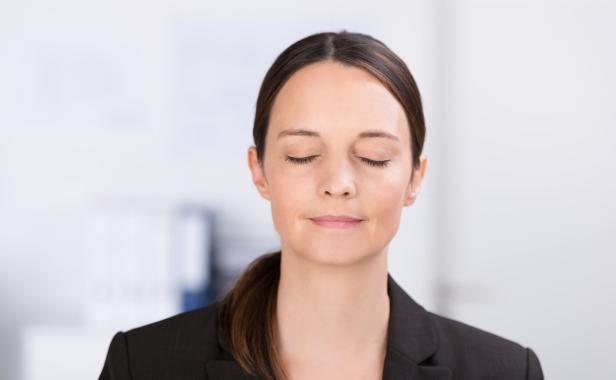 Eine Frau mit geschlossenen Augen und einem leichten Lächeln.