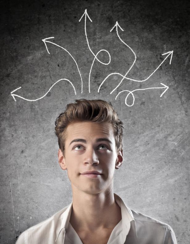 Ein junger Mann blickt nach oben zu mehreren gezeichneten Pfeilen, die in verschiedene Richtungen zeigen.
