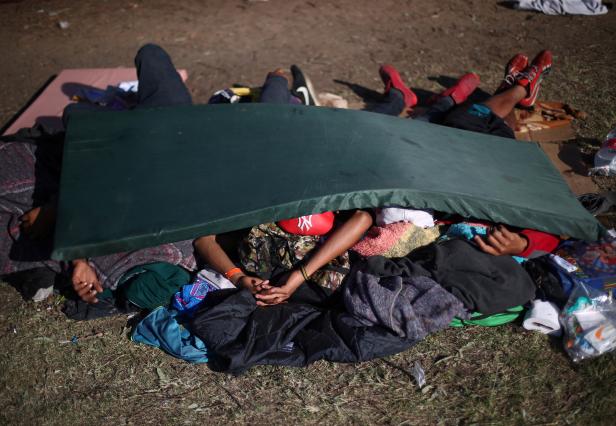Migrants, part of a caravan of thousands from Central America trying to reach the United States, sleep on the ground at a shelter in Tijuana