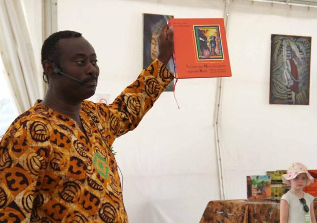 Ein Mann mit Mikrofon präsentiert das Buch „Ich habe den Menschen gerne sagte der Hund“.