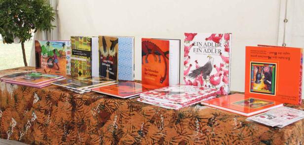 Mehrere Kinderbücher stehen auf einem Tisch mit gemusterter Tischdecke.