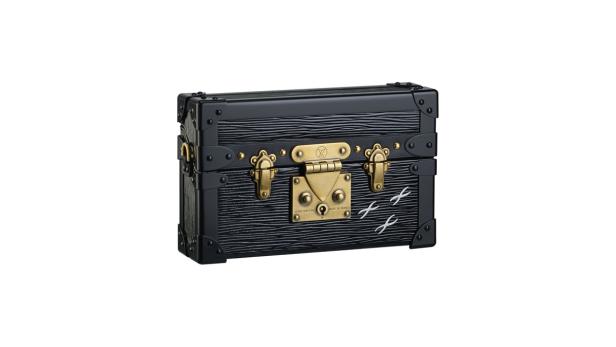 Ein schwarzer Louis Vuitton Mini Trunk mit goldenen Beschlägen und weißen Kreuzen.
