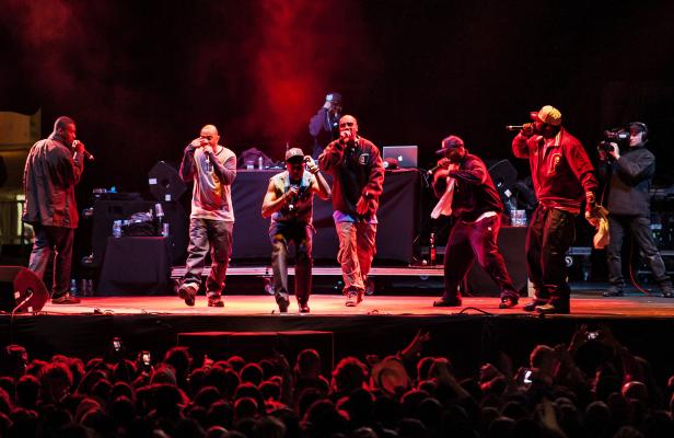 Eine Hip-Hop-Gruppe tritt vor einem Publikum auf einer Bühne auf.