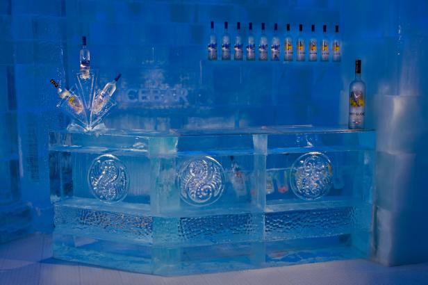 Eine Bar aus Eis mit Flaschen Grey Goose Wodka unter blauem Licht.