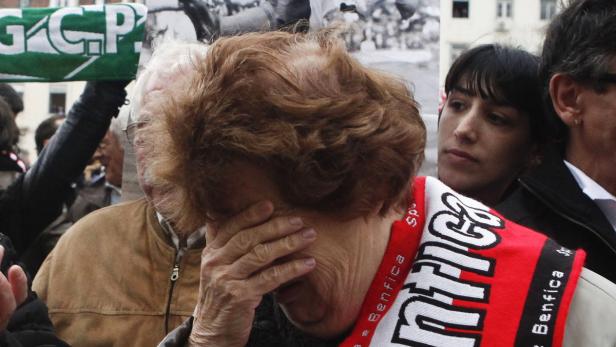 Eine Frau mit einem Benfica-Schal weint in einer Menschenmenge.