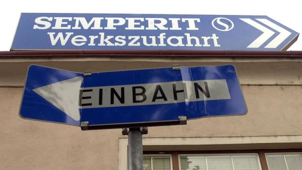 Ein Schild mit der Aufschrift „Semperit Werkszufahrt“ und ein Einbahnstraßenschild.