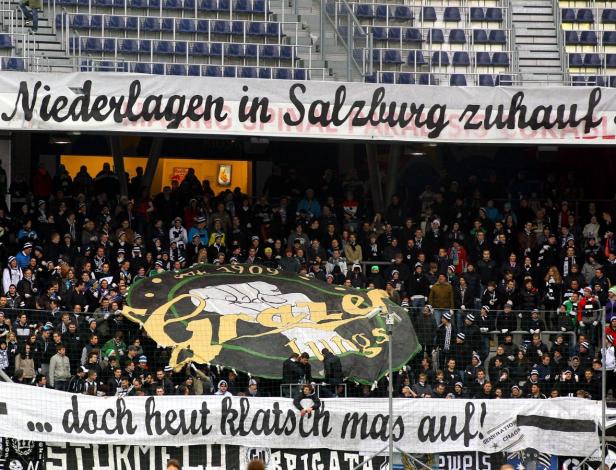 Fußballfans halten Spruchbänder im Stadion hoch.