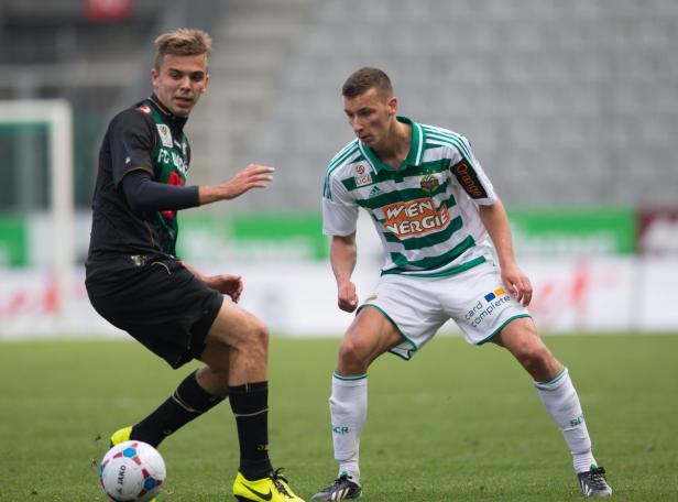 Zwei Fußballspieler stehen sich auf dem Spielfeld gegenüber.