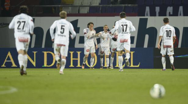 Fußballspieler jubeln auf dem Spielfeld nach einem Tor.