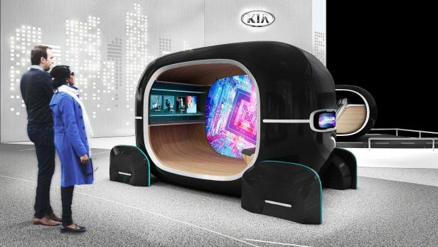 Ein futuristisches Konzeptfahrzeug von Kia wird von zwei Personen betrachtet.