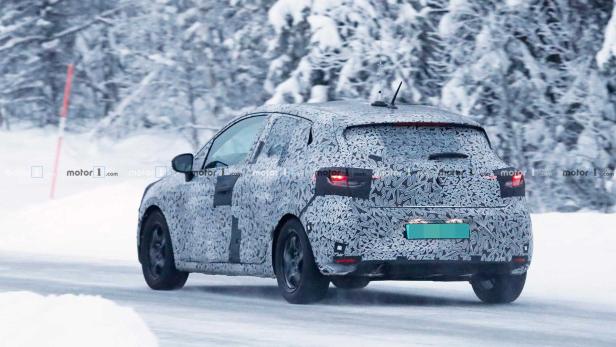 Ein mit Tarnmuster beklebtes Auto fährt auf einer schneebedeckten Straße.