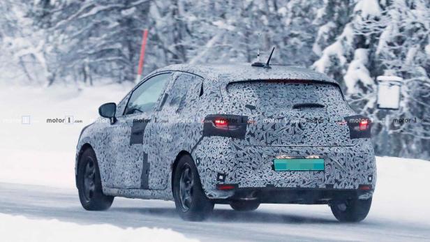 Ein mit Tarnmuster beklebtes Auto fährt auf einer schneebedeckten Straße.