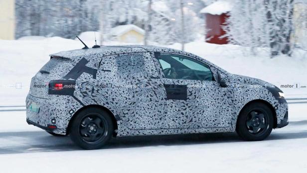 Ein mit Tarnmuster beklebtes Auto fährt auf einer schneebedeckten Straße.