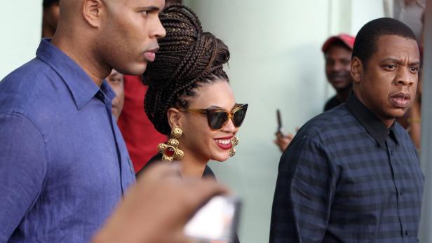 Beyoncé und Jay-Z posieren mit einem Bodyguard für ein Foto.