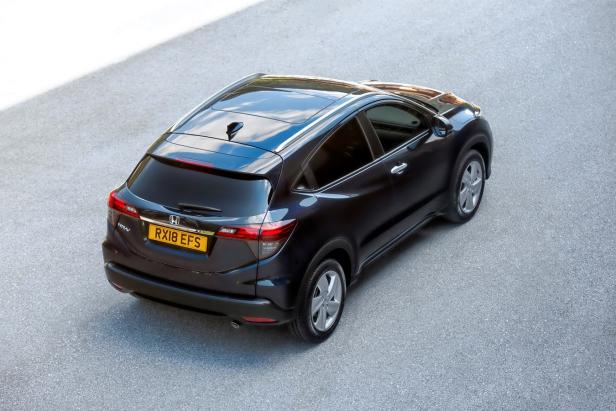 Ein dunkler Honda HR-V steht auf einer grauen Asphaltfläche.