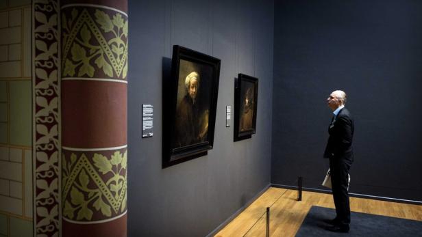 Ein Mann betrachtet Gemälde in einem Museum.