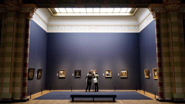 Zwei Personen betrachten Gemälde in einem Saal des Rijksmuseums in Amsterdam.