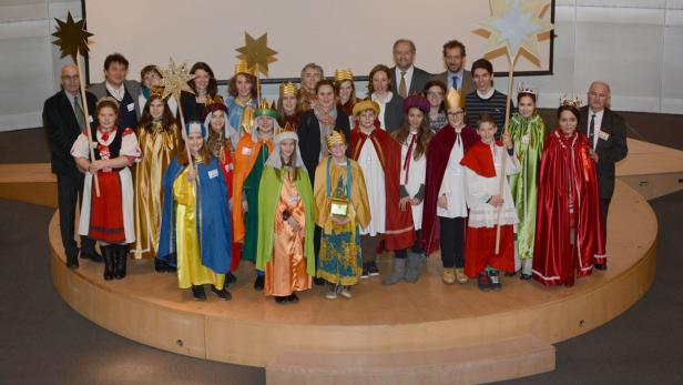Eine Gruppe von Sternsingern steht auf einer Bühne.