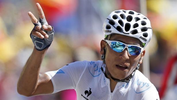 Ein Radrennfahrer mit Helm und Sonnenbrille zeigt das Victory-Zeichen.