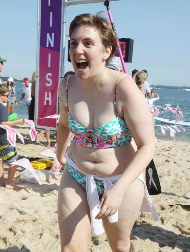 Eine Frau überquert auf einer Wohltätigkeitsveranstaltung die Ziellinie am Strand.