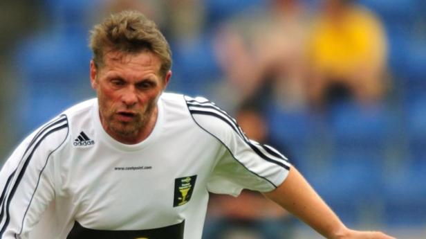 Ein Mann in einem weißen Sporttrikot mit Adidas-Logo.