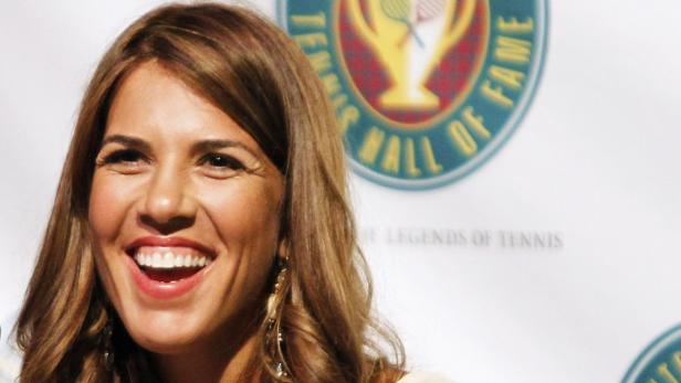 Jennifer Capriati lächelt vor dem Logo der International Tennis Hall of Fame.