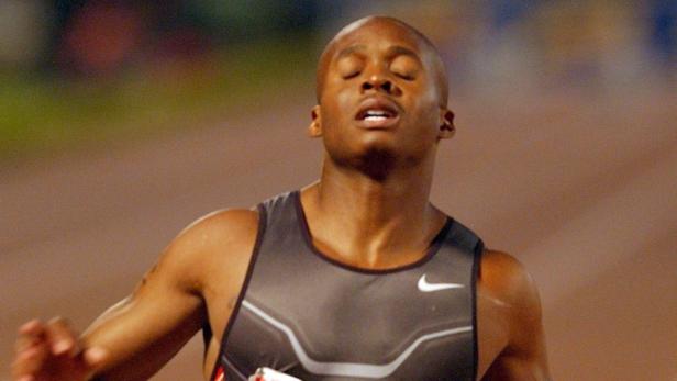 Ein erschöpfter Sprinter mit geschlossenen Augen und offenem Mund.