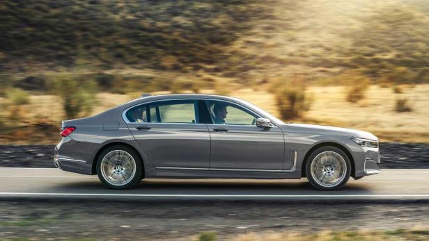 Ein grauer BMW 7er fährt auf einer Landstraße.