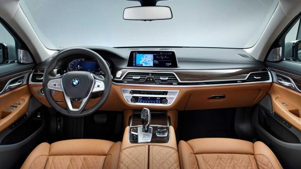 Innenansicht eines BMW mit braunen Ledersitzen und Navigationssystem.