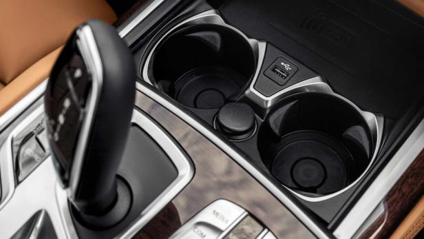 Detailaufnahme der Mittelkonsole eines Autos mit Getränkehaltern und USB-Anschluss.