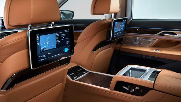 Der Innenraum eines Autos mit Bildschirmen an den Kopfstützen der Vordersitze.