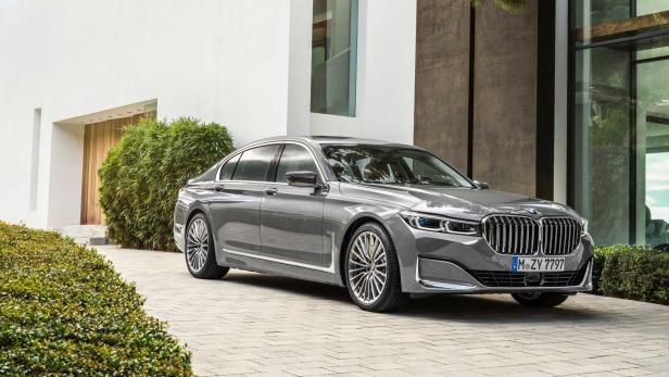 Ein grauer BMW 7er steht vor einem modernen Haus.