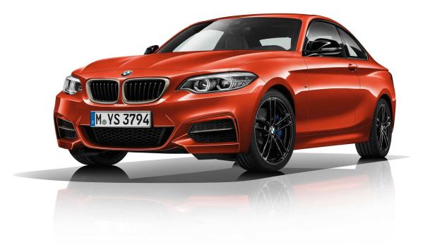 Ein orangefarbener BMW 2er steht auf einem weißen Hintergrund.