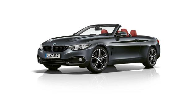 Ein graues BMW 4er Cabriolet mit roten Ledersitzen vor einem weißen Hintergrund.