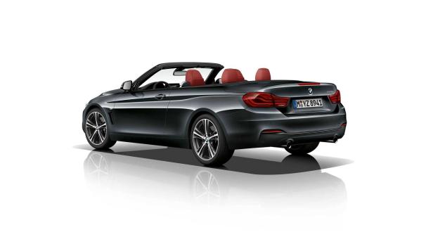 Ein graues BMW 440i Cabriolet mit roten Ledersitzen von hinten.