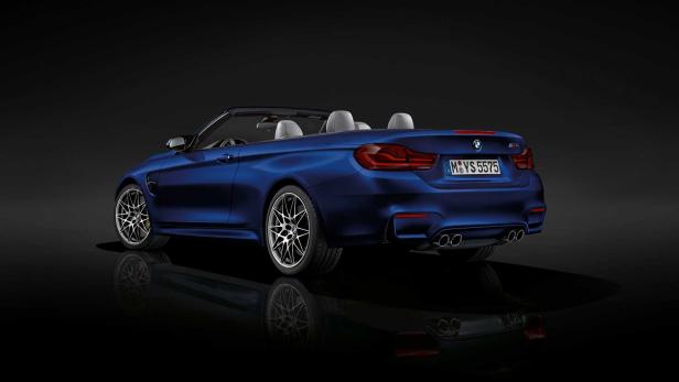 Ein blauer BMW M4 Cabriolet, von hinten aufgenommen, steht auf einem schwarzen Untergrund.