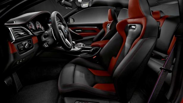 Innenraum eines BMW M4 mit schwarzen und roten Ledersitzen.