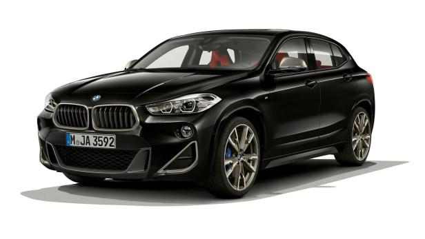 Ein schwarzer BMW X2 mit roten Sitzen vor einem weißen Hintergrund.