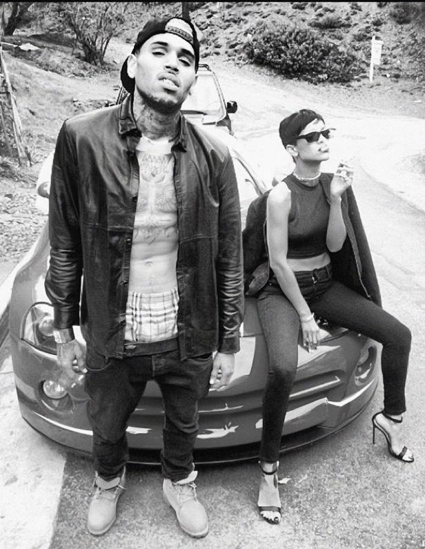 Chris Brown und Rihanna posieren an einem Auto, Rihanna raucht eine Zigarette.
