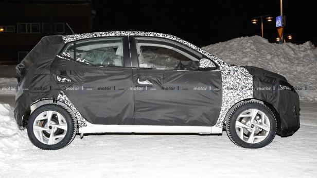 Ein getarntes Auto steht im Schnee.