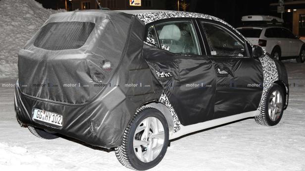 Ein Auto mit Tarnfolie steht im Schnee.