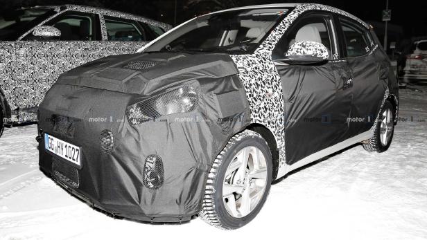 Ein getarntes Auto steht im Schnee.