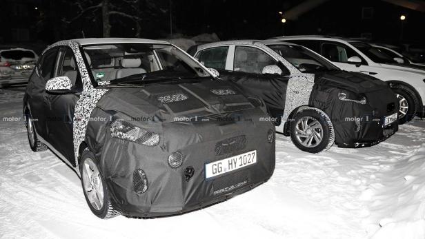 Mehrere getarnte Autos stehen im Schnee.